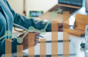 Person am Schreibtisch, die notizen macht zum Thema Recruiting Prozesse optimieren. Vorne sind transparente Balken, die diese Optimierung aufzeigen