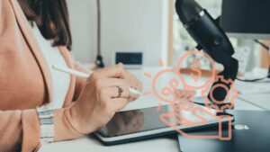 Sarah Boening sitzt am Schreibtisch und schreibt auf ein iPad.