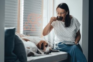 Sarah Boening sitzt am Fenster mit ihrem Hund
